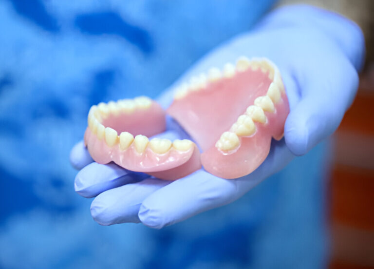 Prothèse dentaire tenue par un professionnel avant nettoyage et polissage au laboratoire JC Anjou Dental à Angers.